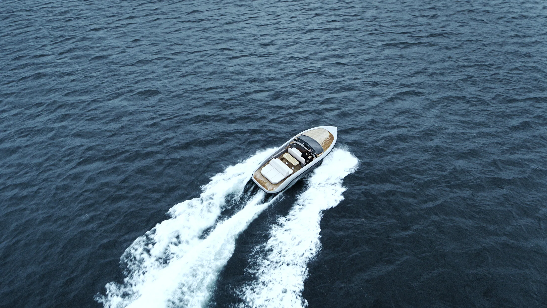 Aerial view of a RAND carving a wake through deep blue water